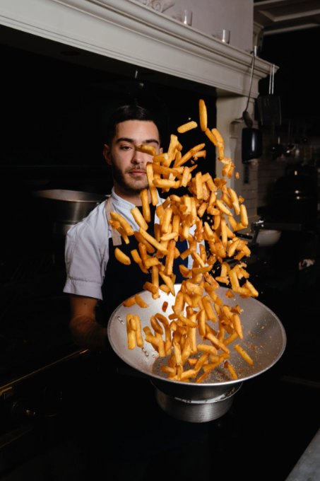 Chef lanzando papas en la sartén